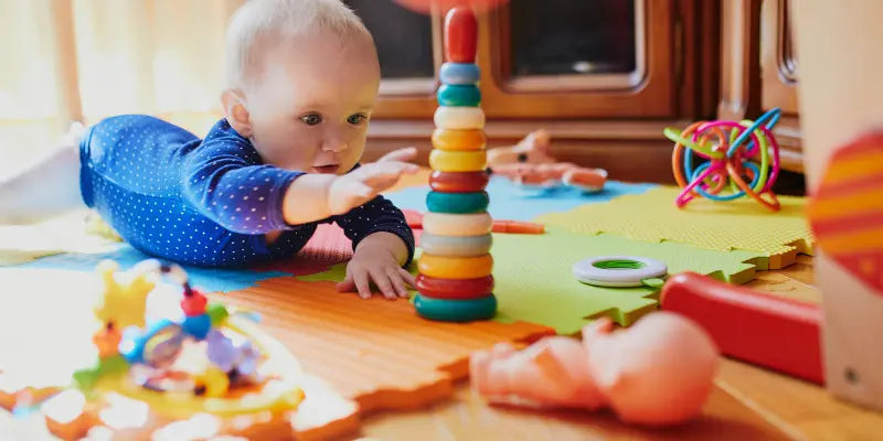 Badleksaker - Carlo baby - ett litet barn leker med färglada klossar från Carlos baby